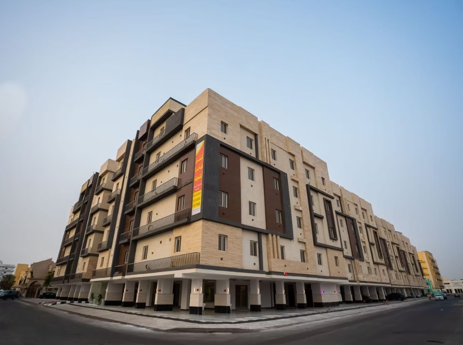 مشرفة - الواجهة الخارجية للعمارة السكنية بحجر بيج ومحلات تجارية في الدور الأرضي - جدة